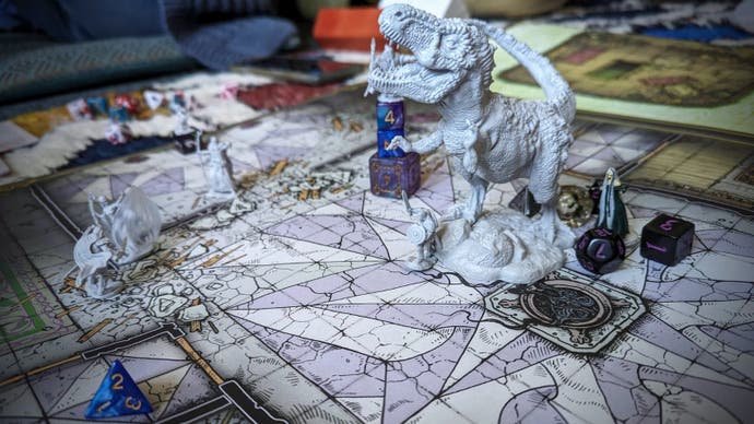 Ein Foto einer großen Dungeons & Dragons Bodenkarte in Postergröße, auf der verschiedene Miniaturen platziert sind. Es gibt ein paar Fantasy-Humanoide, aber der unbestreitbare Mittelpunkt der Szene ist ein gigantischer T-Rex. Das ist Bertie, der für diesen Anlass polymorphisiert wurde. Das hat ihn im Kampf gehalten.