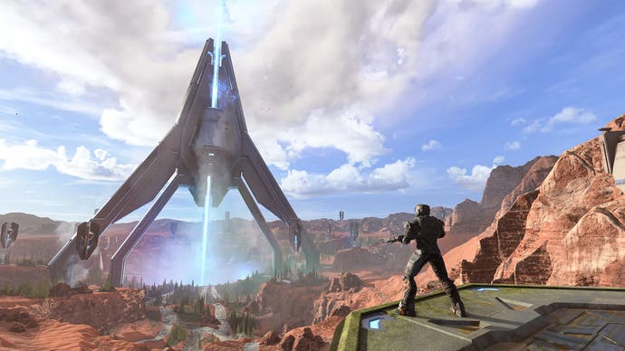 Die Karte Oasis in Halo Infinite - ein riesiges Metallgebäude schießt Licht in den Boden, während der Spieler zuschaut.