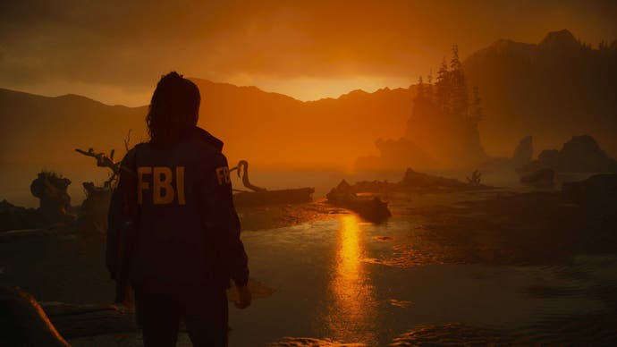 Saga Anderson blickt in Alan Wake 2 bei Sonnenuntergang auf den Cauldron Lake. Sie trägt eine FBI-Jacke und hat ihr Haar zu einem Pferdeschwanz zurückgebunden.